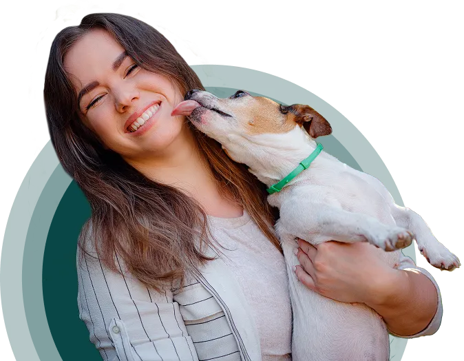 A smiling person holding a happy dog