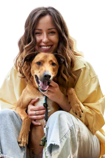 A pet parent joyfully hugging their dog